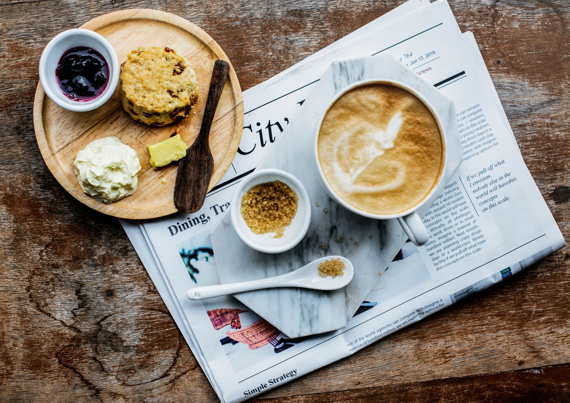 Mesa con un cafe conleche junto a unas galletas 